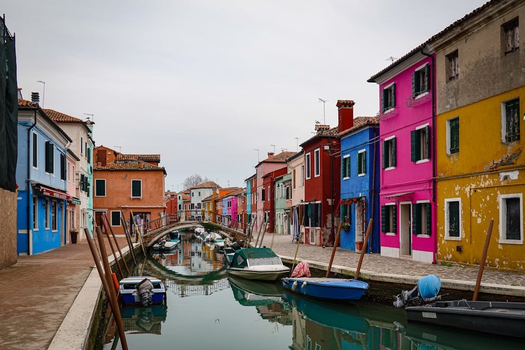 A scenic view of colorful houses along a canal in Burano, Italy.